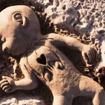 Scultura in sabbia sul litorale sardo per il piccolo Domenico. Cuoricino stilizzato in evidenza sul petto